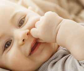 0 portrait sweet smiling newborn daughter lying cozy bed child looks camera touching face with her little hands childhood moments 2